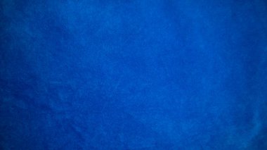 Arka plan olarak mavi kadife kumaş dokusu kullanılıyor. Yumuşak ve pürüzsüz tekstil malzemelerinin boş mavi kumaş arka planı. Metin için boşluk var.