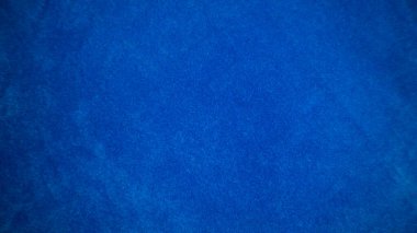 Arka plan olarak mavi kadife kumaş dokusu kullanılıyor. Yumuşak ve pürüzsüz tekstil malzemelerinin boş mavi kumaş arka planı. Metin için boşluk var.