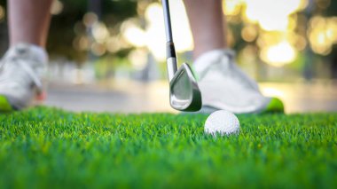 Golf ball close up on tee grass on blurred beautiful landscape of golf background. Concept international sport that rely on precision skills for health relaxation..	