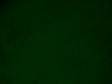 Arka plan olarak kullanılan koyu yeşil kadife kumaş dokusu. Yumuşak ve pürüzsüz tekstil malzemelerinden oluşan orman yeşili kumaş. Metin için boşluk var.