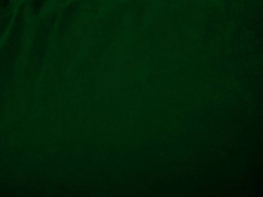 Arka plan olarak kullanılan koyu yeşil kadife kumaş dokusu. Yumuşak ve pürüzsüz tekstil malzemelerinden oluşan orman yeşili kumaş. Metin için boşluk var.