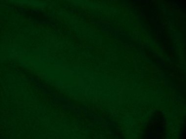 Arka plan olarak kullanılan koyu yeşil kadife kumaş dokusu. Yumuşak ve pürüzsüz tekstil malzemelerinden oluşan orman yeşili kumaş. Metin için boşluk var.