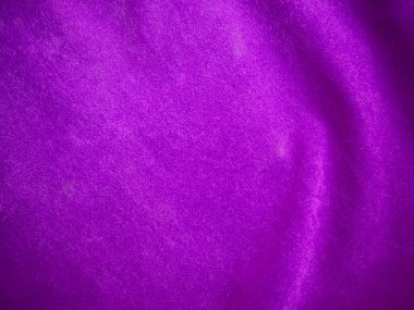 Arka plan olarak kullanılan mor kadife kumaş dokusu. Yumuşak ve pürüzsüz tekstil malzemelerinin lükslü mor kumaş arka planı. Metin için boşluk var.
