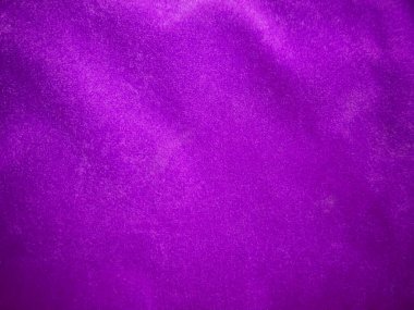 Arka plan olarak kullanılan mor kadife kumaş dokusu. Yumuşak ve pürüzsüz tekstil malzemelerinin lükslü mor kumaş arka planı. Metin için boşluk var.