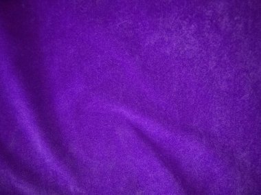 Arka plan olarak kullanılan mor kadife kumaş dokusu. Yumuşak ve pürüzsüz tekstil malzemelerinin lükslü mor kumaş arka planı. Metin için boşluk var.