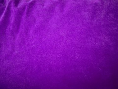 Arka plan olarak kullanılan mor kadife kumaş dokusu. Yumuşak ve pürüzsüz tekstil malzemelerinin lükslü mor kumaş arka planı. Metin için boşluk var.