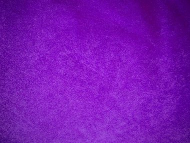 Arka plan olarak kullanılan mor kadife kumaş dokusu. Yumuşak ve pürüzsüz tekstil malzemelerinin lükslü mor kumaş arka planı. Metin için boşluk var.