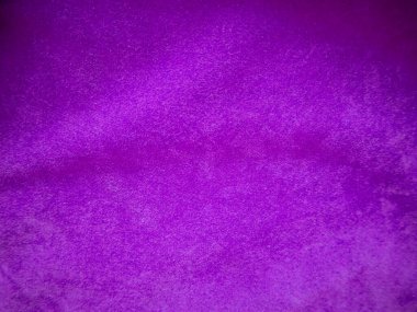 Arka plan olarak kullanılan mor kadife kumaş dokusu. Yumuşak ve pürüzsüz tekstil malzemelerinin lükslü mor kumaş arka planı. Metin için boşluk var.
