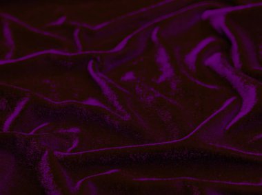 Arka plan olarak kullanılan mor kadife kumaş dokusu. Yumuşak ve pürüzsüz tekstil malzemelerinin boş mor kumaş arkaplanı. Metin için boşluk var