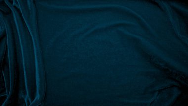 Arka plan olarak mavi kadife kumaş dokusu kullanılıyor. Yumuşak ve pürüzsüz tekstil malzemelerinin tavus kuşu renkli kumaş arka planı. Ezilmiş kadife. İpek için lüks donanma tonu..