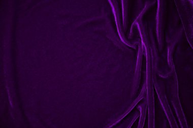 Arka plan olarak kullanılan mor kadife kumaş dokusu. Yumuşak ve pürüzsüz tekstil malzemelerinin mor renkli kumaş arka planı. Ezilmiş kadife. İpek için lüks morumsu ton..