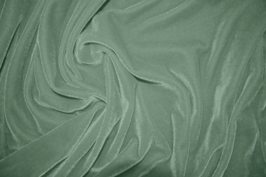 Arka plan olarak zeytin yeşili kadife kumaş dokusu kullanılır. Yumuşak ve pürüzsüz tekstil malzemesinin yeşil panne kumaş arka planı. Ezilmiş kadife. İpek için lüks altın rengi. Pembe altın.