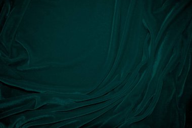 Green velvet fabric texture used as background. Peacock color panne fabric background of soft and smooth textile material. crushed velvet .luxury emerald tone for silk.	