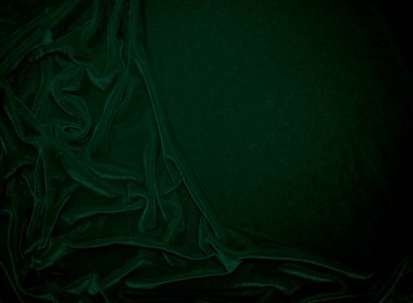 Green velvet fabric texture used as background. Emerald color panne fabric background of soft and smooth textile material. crushed velvet .luxury emerald tone for silk.	