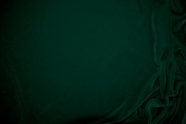 Green velvet fabric texture used as background. Emerald color panne fabric background of soft and smooth textile material. crushed velvet .luxury emerald tone for silk.	