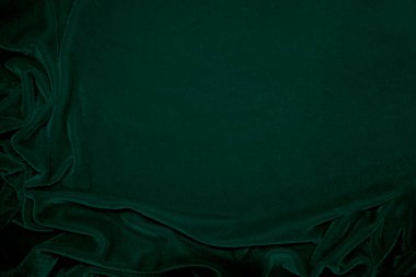 Green velvet fabric texture used as background. Emerald color panne fabric background of soft and smooth textile material. crushed velvet .luxury emerald tone for silk.	