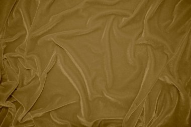 golden velvet fabric texture used as background. blond color panne fabric background of soft and light brown smooth textile material. crushed velvet .luxury yellow tone for silk.	