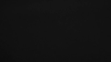 Arka plan olarak kullanılan koyu siyah kadife kumaş dokusu. yumuşak ve pürüzsüz tekstil malzemesinden siyah panne kumaş arkaplan. Ezilmiş kadife. İpek için gece tonu.