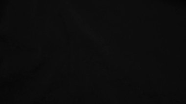 Arka plan olarak kullanılan koyu siyah kadife kumaş dokusu. yumuşak ve pürüzsüz tekstil malzemesinden siyah panne kumaş arkaplan. Ezilmiş kadife. İpek için gece tonu.