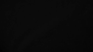 Arka plan olarak kullanılan koyu siyah kadife kumaş dokusu. yumuşak ve pürüzsüz tekstil malzemesinden siyah panne kumaş arkaplan. Ezilmiş kadife. İpek için gece tonu.