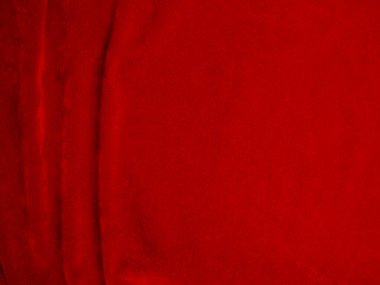 Arka plan olarak kırmızı kadife kumaş dokusu kullanılıyor. Yumuşak ve pürüzsüz tekstil malzemelerinin kırmızı paneli. Ezilmiş kadife. İpek için lüks kırmızı..
