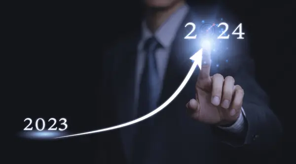 Businessman holding a wooden block. Dart board, conceptualization to lead to the right goal. cube block to contain the purpose of doing business overcoming. Developing ideas for the new year 2024.	