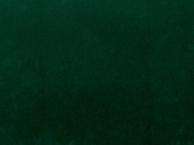 Arkaplan olarak kullanılan yeşil kadife kumaş dokusu. Yumuşak ve pürüzsüz tekstil malzemelerinden oluşan boş yeşil kumaş arka planı. Metin için boşluk var.