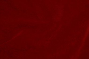Arka plan olarak kullanılan koyu kırmızı kadife kumaş dokusu. Yumuşak ve pürüzsüz tekstil malzemelerinin ipek rengi kırmızı kumaş arka planı. Ezilmiş kadife. İpek için lüks koyu renk..