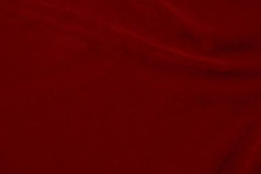 Arka plan olarak kullanılan koyu kırmızı kadife kumaş dokusu. Yumuşak ve pürüzsüz tekstil malzemelerinin ipek rengi kırmızı kumaş arka planı. Ezilmiş kadife. İpek için lüks koyu renk..