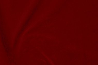 Arka plan olarak kullanılan koyu kırmızı kadife kumaş dokusu. Yumuşak ve pürüzsüz tekstil malzemelerinin ipek rengi kırmızı kumaş arka planı. Ezilmiş kadife. İpek için lüks koyu renk..