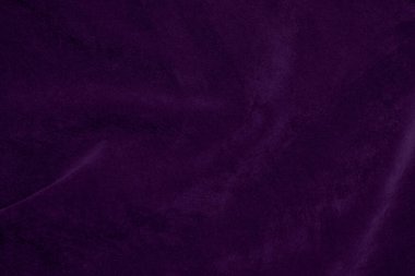 Arka plan olarak kullanılan koyu mor kadife kumaş dokusu. Yumuşak ve pürüzsüz tekstil malzemesinin mor renkli kumaş arka planı. Ezilmiş kadife. İpek için lüks koyu renk..