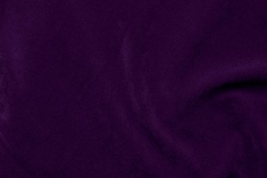 Arka plan olarak kullanılan koyu mor kadife kumaş dokusu. Yumuşak ve pürüzsüz tekstil malzemesinin mor renkli kumaş arka planı. Ezilmiş kadife. İpek için lüks koyu renk..
