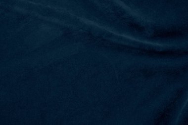 Arka plan olarak kullanılan koyu mavi kadife kumaş dokusu. Yumuşak ve pürüzsüz tekstil malzemelerinin ipek renkli kumaş arka planı. Ezilmiş kadife. Lüks lacivert ipeğin koyu tonu..