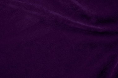 Arka plan olarak kullanılan koyu mor kadife kumaş dokusu. Yumuşak ve pürüzsüz tekstil malzemesinin mor renkli kumaş arka planı. Ezilmiş kadife. İpek için lüks koyu renk..