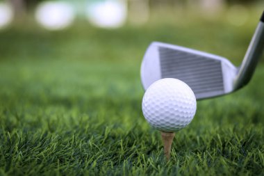Golf topu golf arka planının bulanık güzellikteki golf sahasında çimlere yakın duruyor. Sağlık gevşemesi için hassas becerilere dayanan uluslararası spor kavramını kabul edin