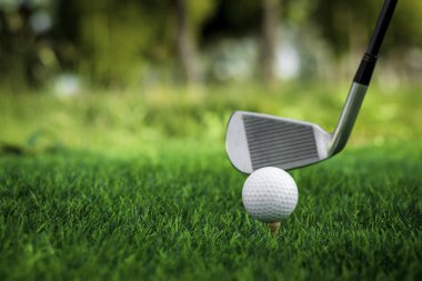 Golf topu golf arka planının bulanık güzellikteki golf sahasında çimlere yakın duruyor. Sağlık gevşemesi için hassas becerilere dayanan uluslararası spor kavramını kabul edin