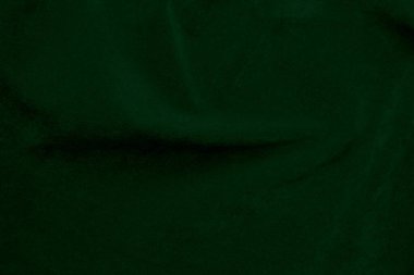 Arka plan olarak kullanılan koyu yeşil kadife kumaş dokusu. Yumuşak ve pürüzsüz tekstil malzemelerinin zümrüt renkli kumaş arka planı. Ezilmiş kadife. İpek için lüks zümrüt rengi....