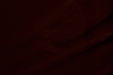 Arka plan olarak kullanılan koyu kırmızı kadife kumaş dokusu. Yumuşak ve pürüzsüz tekstil malzemelerinin ipek rengi kırmızı kumaş arka planı. Ezilmiş kadife. İpek için lüks koyu renk..