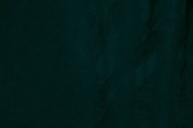 Arka plan olarak kullanılan koyu yeşil kadife kumaş dokusu. Yumuşak ve pürüzsüz tekstil malzemelerinin zümrüt renkli kumaş arka planı. Ezilmiş kadife. İpek için lüks zümrüt rengi....