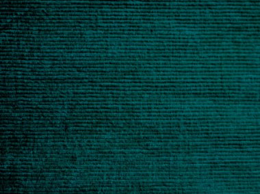 Mavi ve yeşil çizgili bir halı. Halı yumuşak ve pelüş bir malzemeden yapılmıştır. Çizgiler farklı renk ve boyutlarda, eşsiz ve ilginç bir desen oluşturuyor.