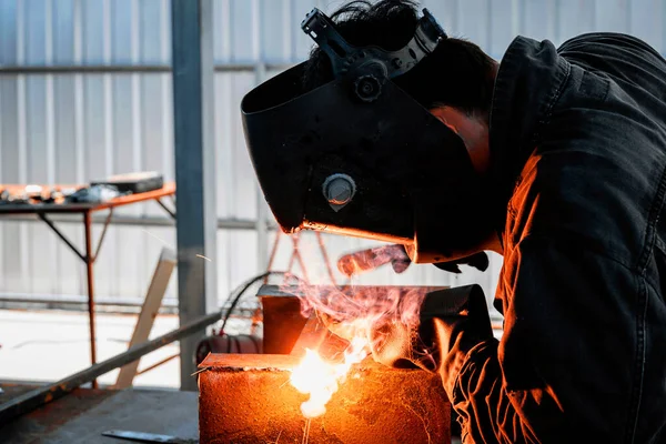 Male workers wear masks to prevent smoke and sparks caused by welding.