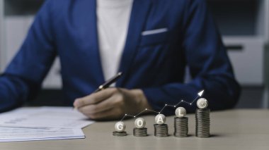 Yatırım hedef para yığını konsepti. Aşağıdan yukarıya doğru giden bozuk paralar daha fazla büyümek için yatırım parasıyla karşılaştırılabilir. Hisselere yatırım yaparak tasarruf ve tasarruf kavramı