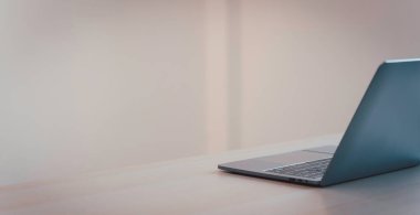 Ofis arkaplanındaki masada dizüstü bilgisayar.