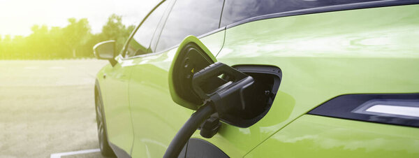 электрический автомобиль, заряженный на зарядной станции. порт для зарядки и кабель, отражающие концепцию чистой энергии, электромобилей и современных транспортных технологий