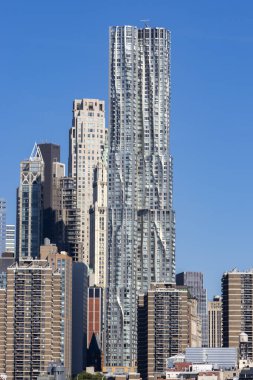 Görüntü, New York 'taki parlak cam gökdelenleri yakalıyor. Açık bir öğleden sonra güneş ışığını yansıtıyor. Modern tasarımı kentsel manzaralarla harmanlıyor..