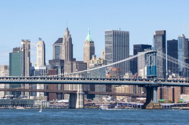 Williamsburg Köprüsü Manhattan ve Brooklyn 'i araçlar ve yayalar ile birbirine bağlarken, Doğu Nehri aşağıdan akar, dramatik bulutlar ve şehrin ufuk çizgisi tarafından çerçevelenir..