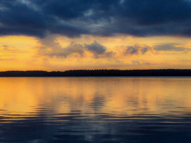 Körfezin üzerindeki Pastel Alacakaranlık: Yumuşak pastel renkler, Finlandiya Körfezi 'nin sakin yüzeyinde gökyüzünü ve aynasını boyar ve huzurlu bir yaz günbatımını görüntüler..