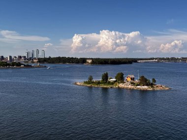 Güneşli bir günde arka planında Helsinki 'nin ufuk çizgisi olan küçük Finlandiya adası