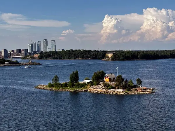 Güneşli bir günde arka planında Helsinki 'nin ufuk çizgisi olan küçük Finlandiya adası