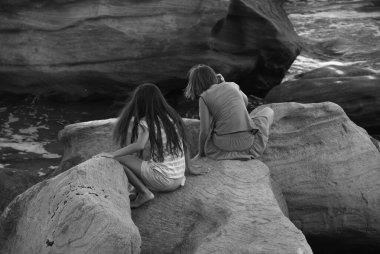 kids playing on the rocks in the beach